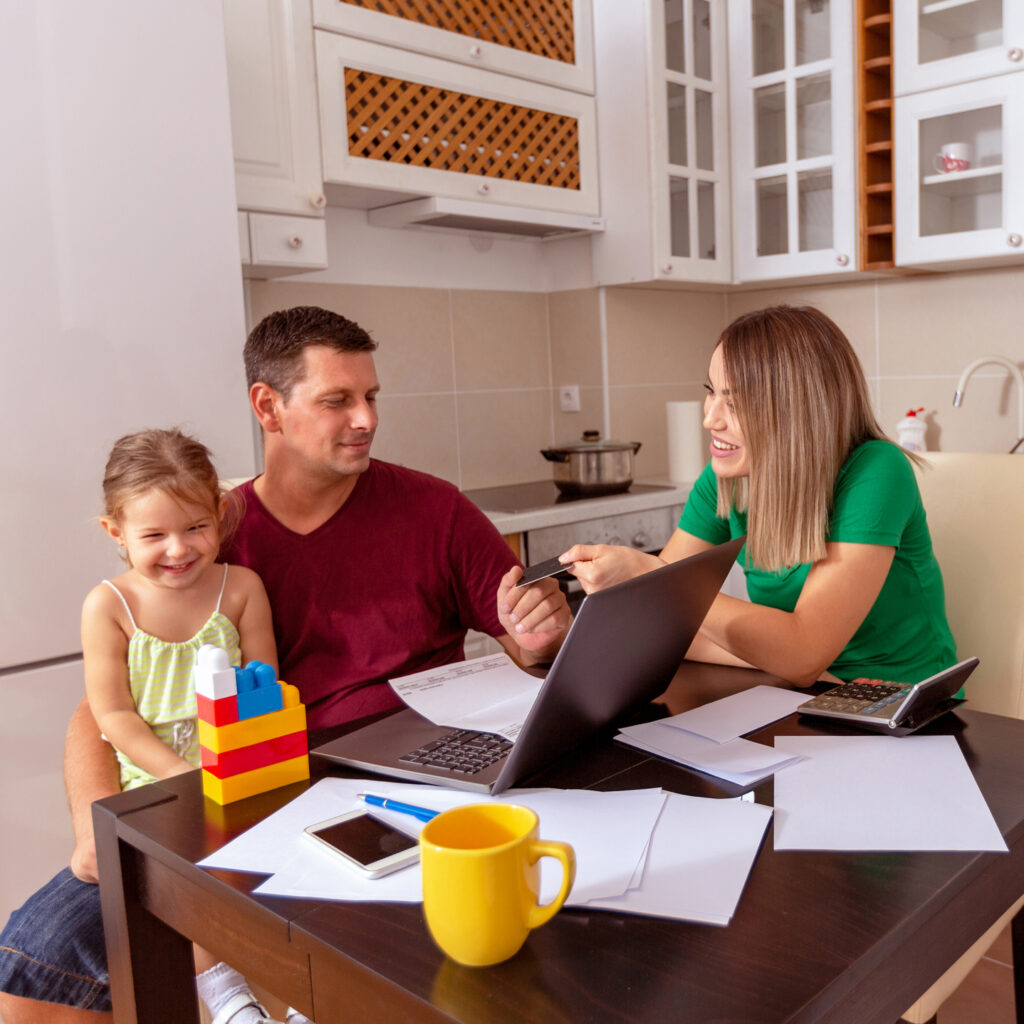 Busy Family Home with Father Working as Mother Prepares Meal