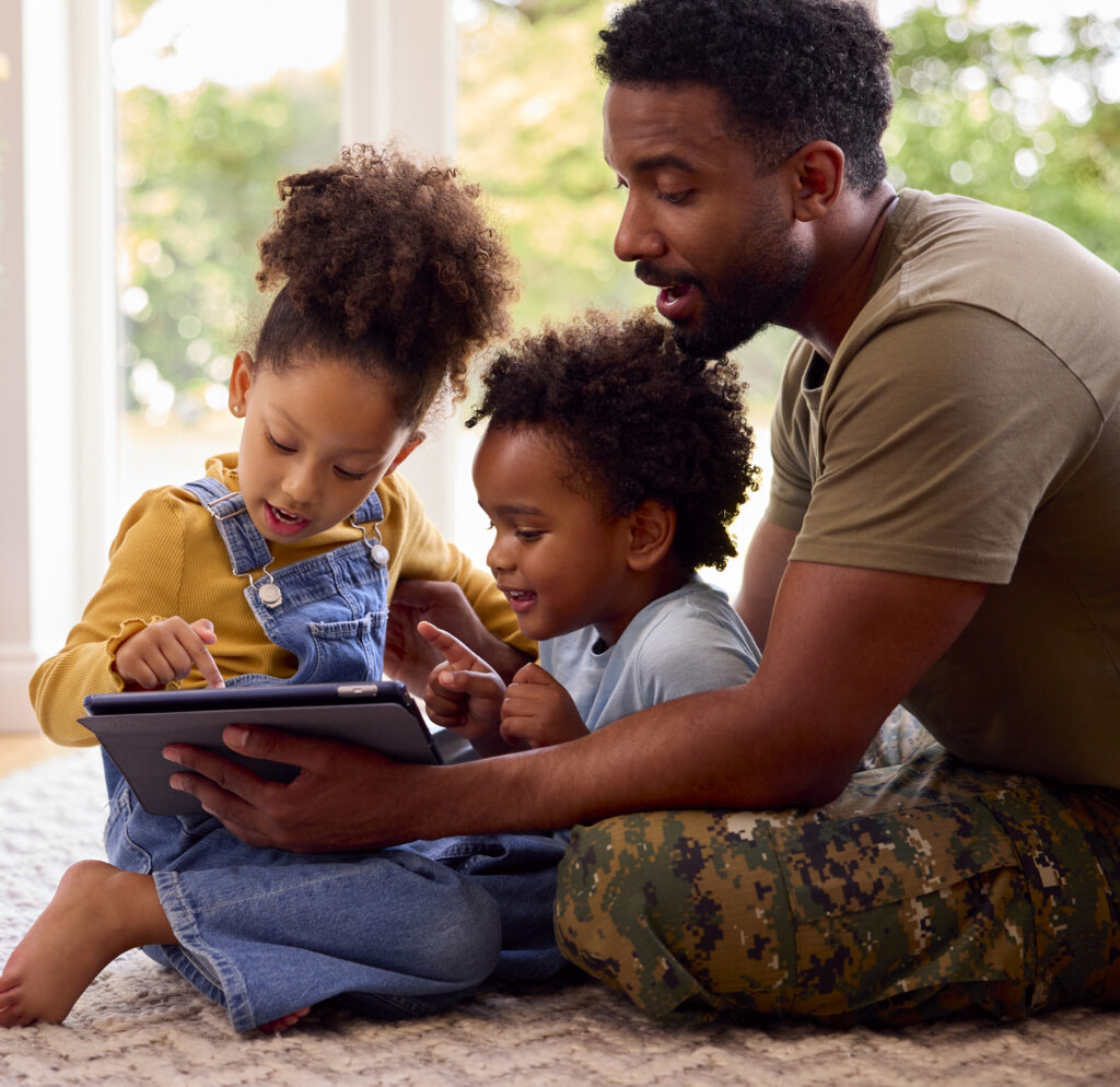 Army Father In Uniform Home On Leave With Children Using Digital Tablet