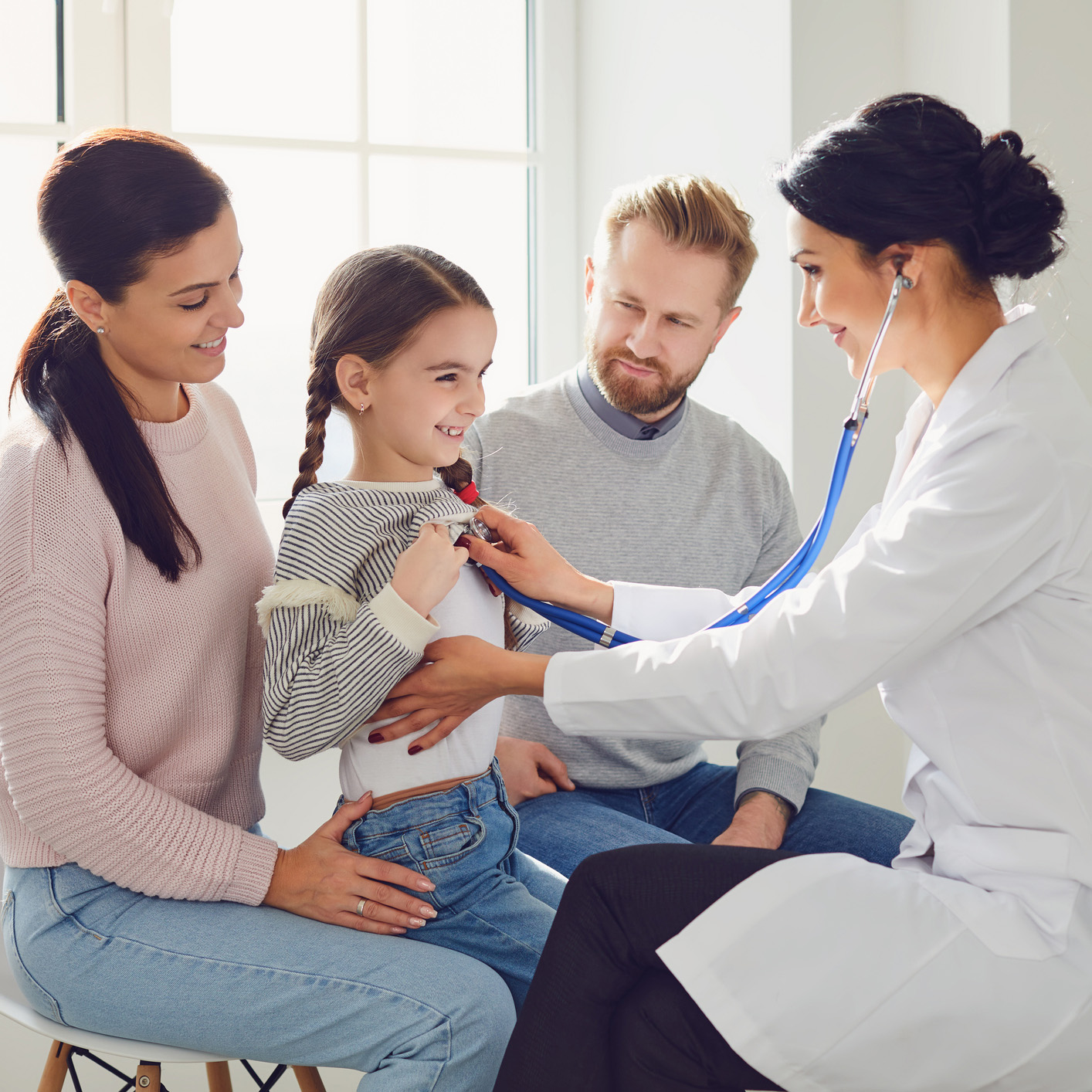 Happy family on a visit to the doctor in the office of a doctor.