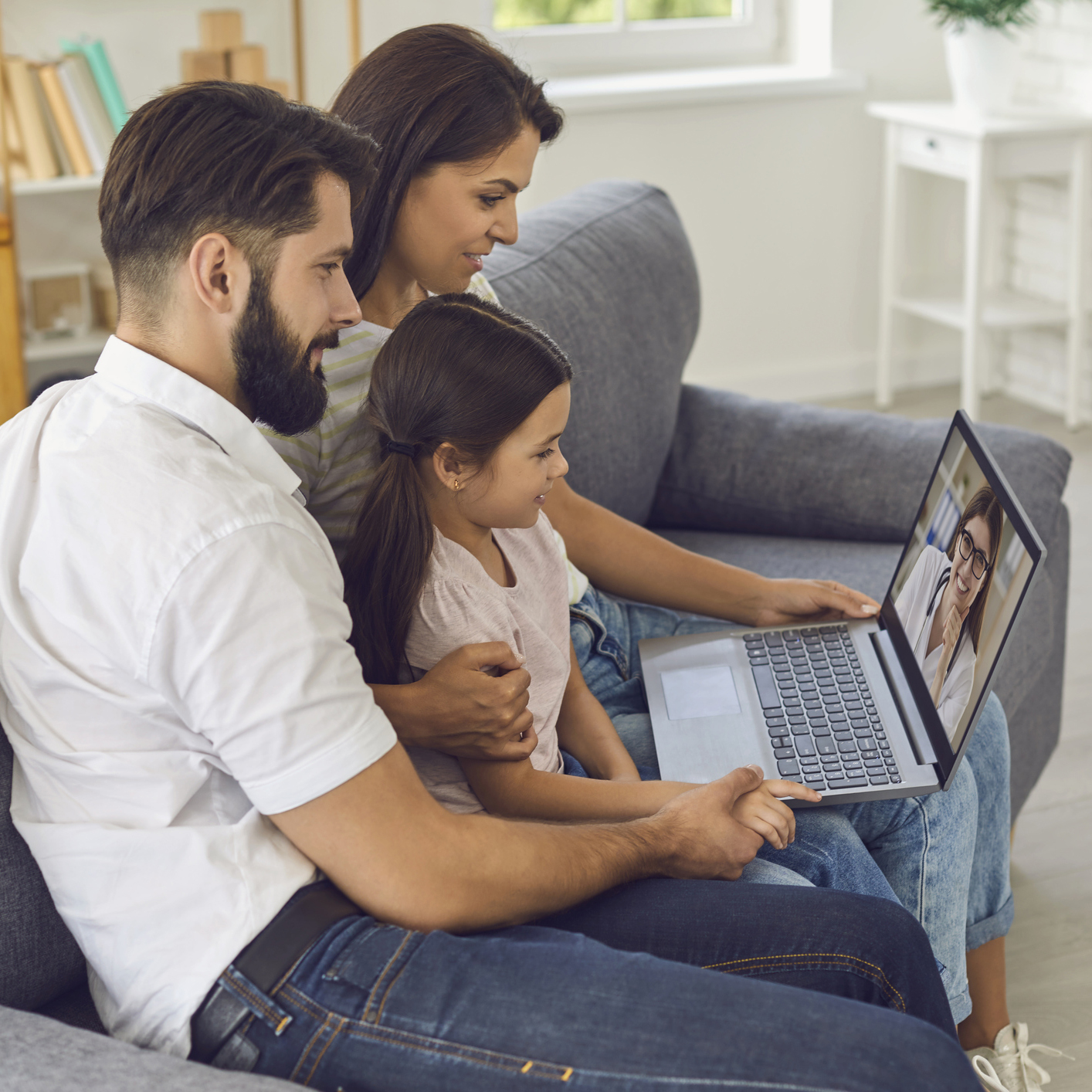 Family doctor online. Happy family consults using video conference computer at home.