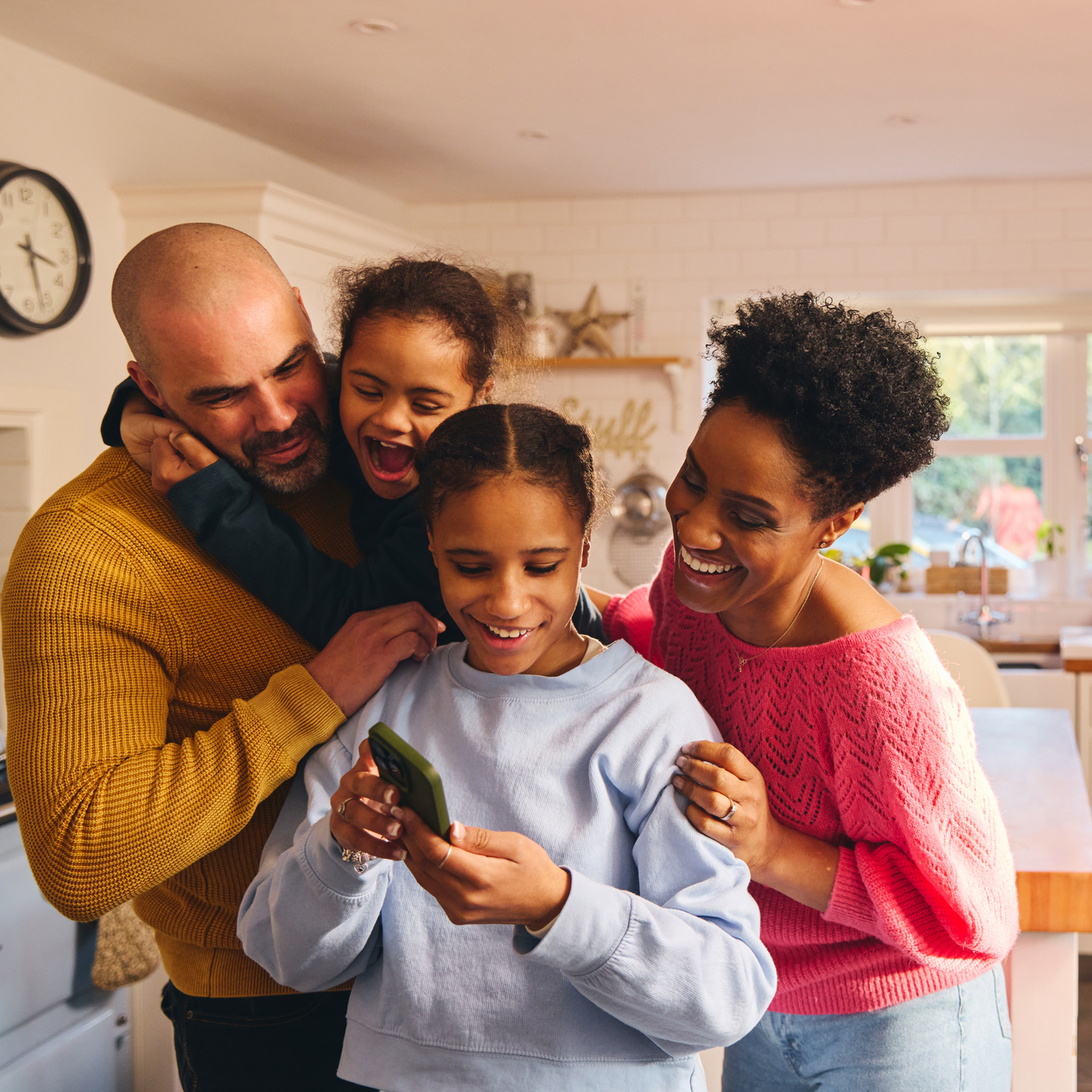 Teen girl looking at selfie on phone with family