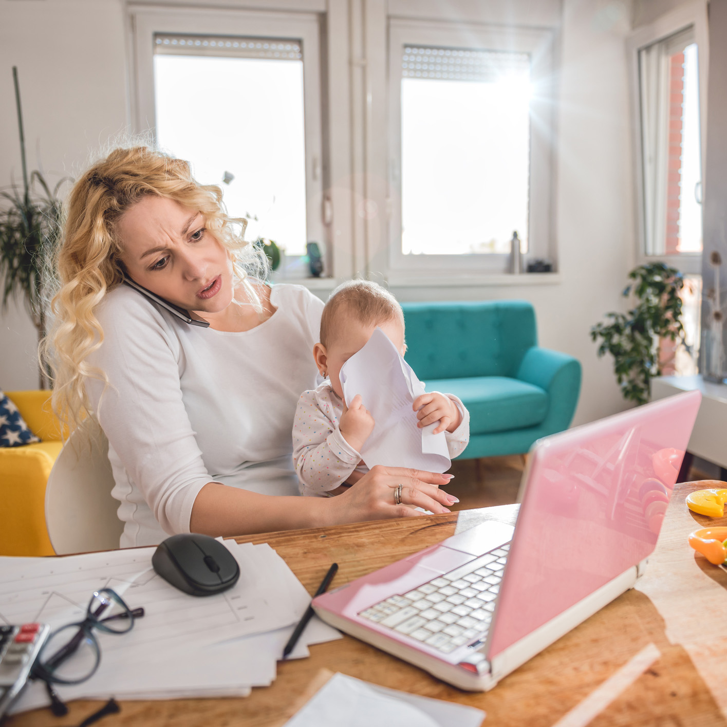 Mother talking on smart phone at home office