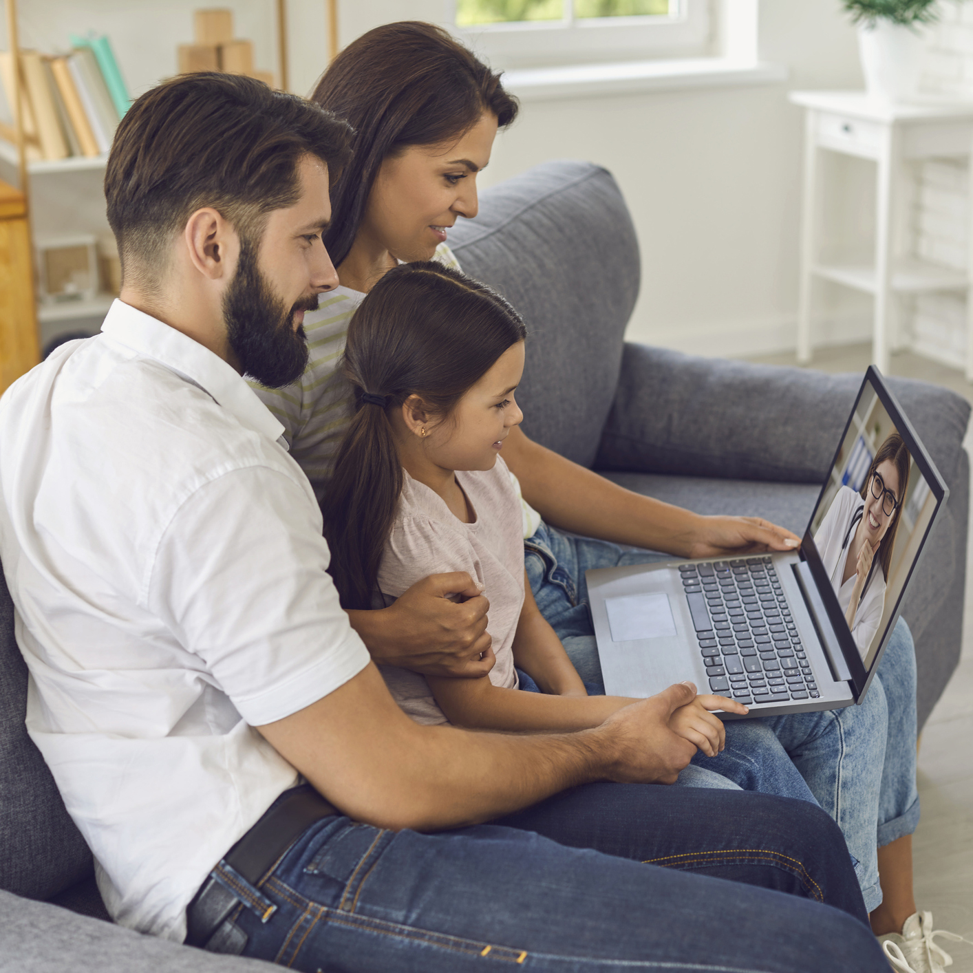 Family doctor online. Happy family consults using video conference computer at home.