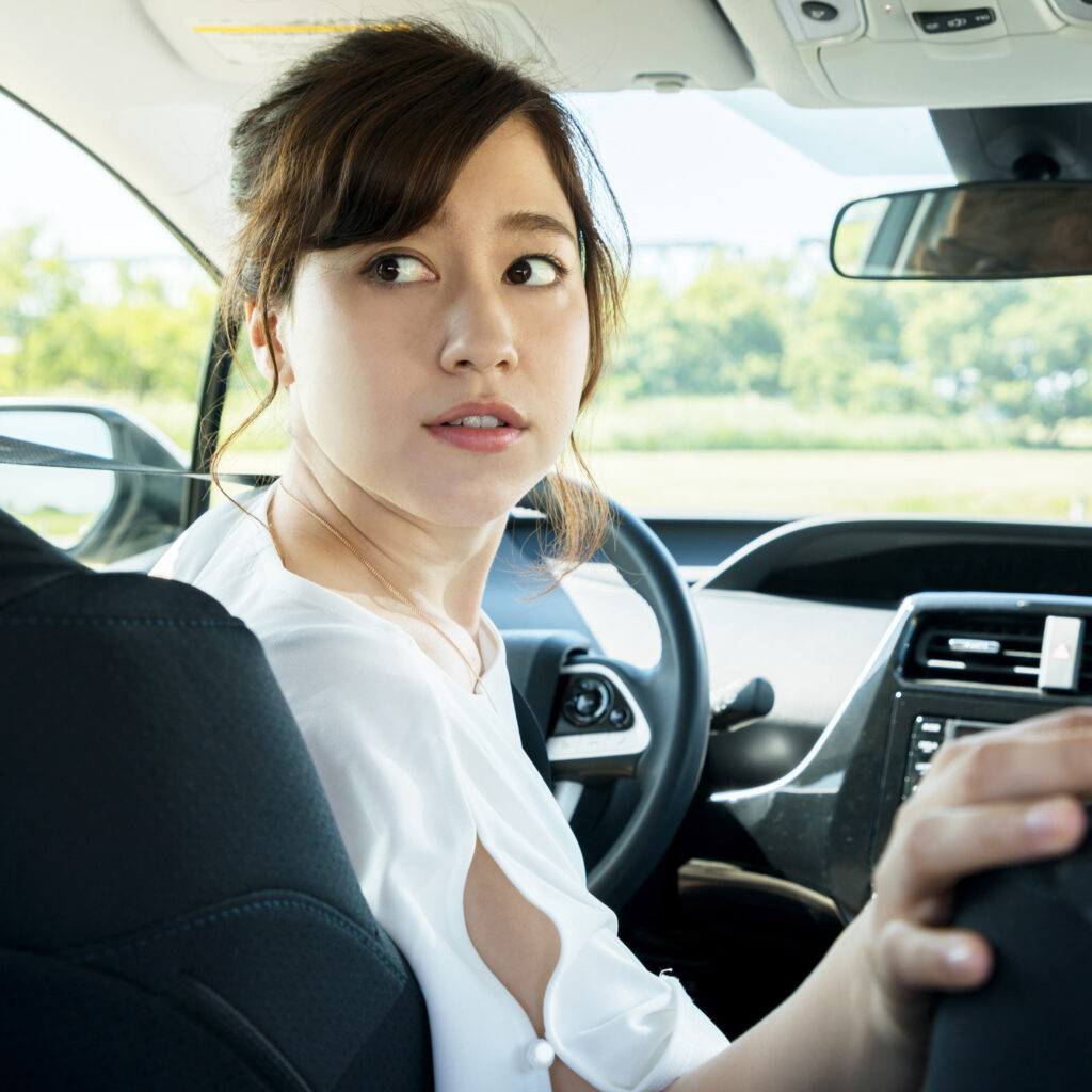 young woman driver turning back.