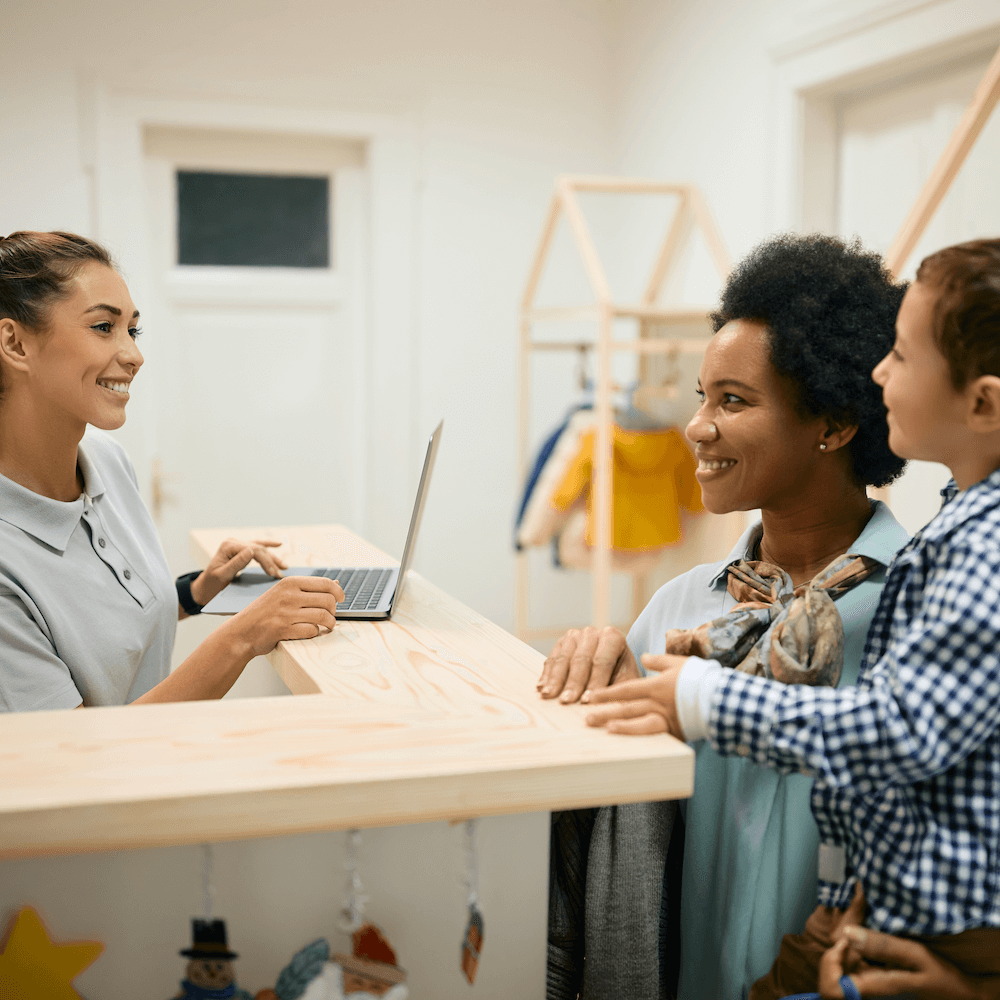 Mother with young son in daycare at the front desk. Mother with young son in daycare at the front desk.