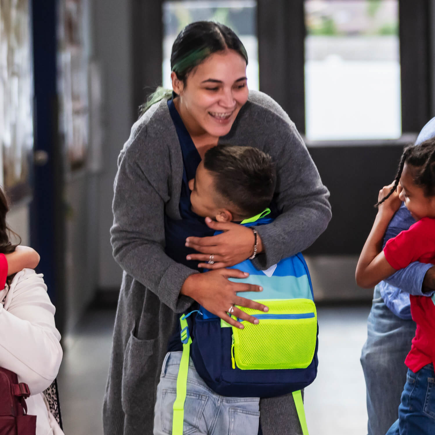 Young kid hugging their teacher.