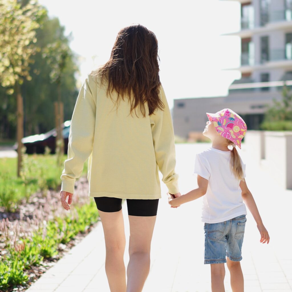Mother and daughter holidng hands walking outside
