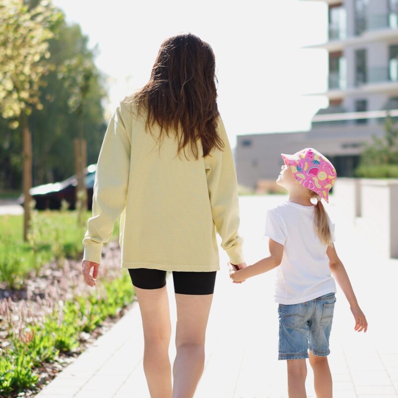 Mother and daughter holidng hands walking outside